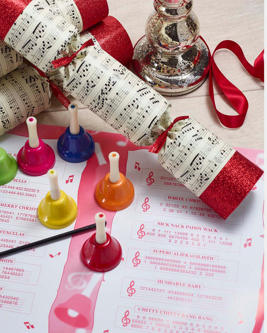 Hand bell Christmas crackers with musical notes and numbered badges