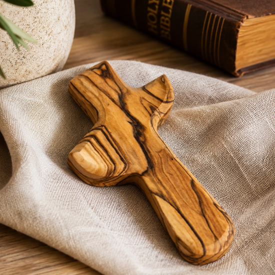 Hand-carved olive wood holding cross sized to fit in the palm of the hand
