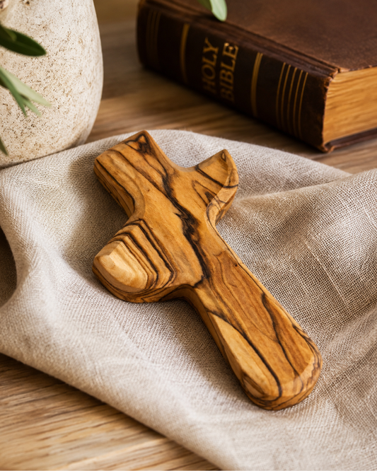 Hand-carved olive wood holding cross sized to fit in the palm of the hand
